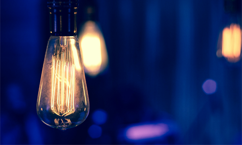 Light Bulb lit up against purple background